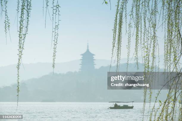 silhouetted fishing boat on west lake, hangzhou, china - west lake hangzhou 個照片及圖片檔