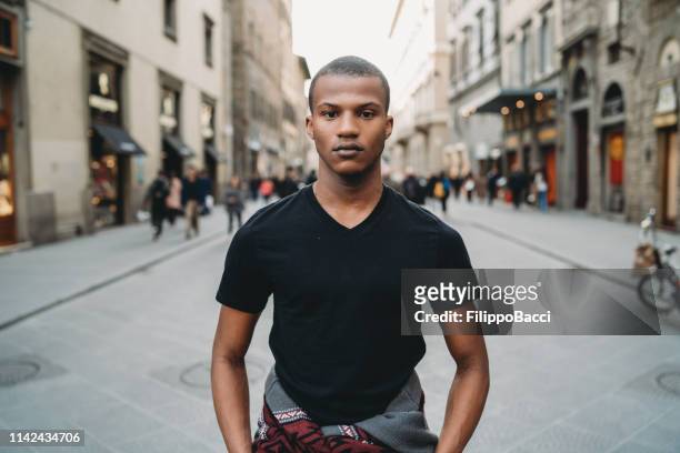 porträtt av en ung vuxen man i staden - slim bildbanksfoton och bilder