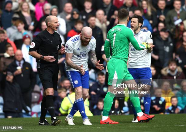 Harry Arter of Cardiff City argues with referee Mike Dean as Aron Gunnarsson of Cardiff City reacts during the Premier League match between Burnley...