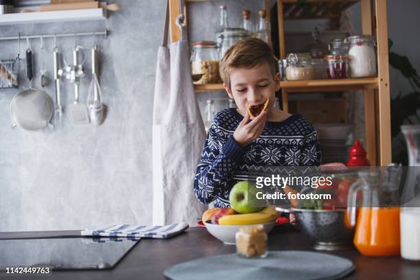 boy eating pancakes in the kitchen - winter jam stock pictures, royalty-free photos & images
