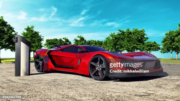 electric sports car charging batteries charged at parking lot - red car wire stock pictures, royalty-free photos & images