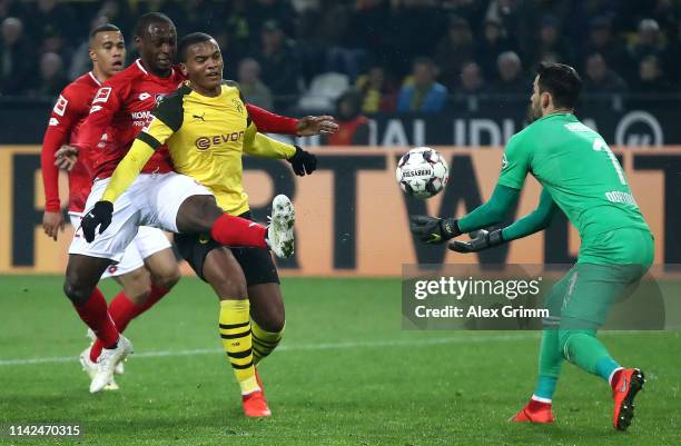 Anthony Ujah of FSV Mainz stretches for the ball under pressure from Manuel Akanji and Roman Buerki of Borussia Dortmund during the Bundesliga match...