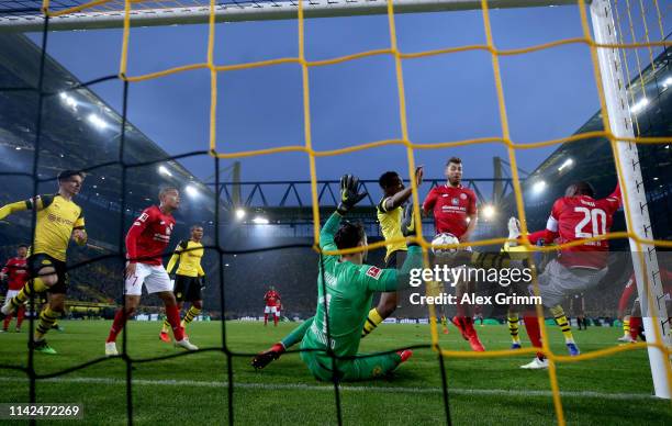 Anthony Ujah of FSV Mainz shoots under pressure from Dan-Axel Zagadou and Roman Buerki of Borussia Dortmund during the Bundesliga match between...