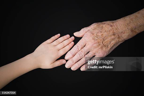 getting older – young and old hands - lentigo stockfoto's en -beelden