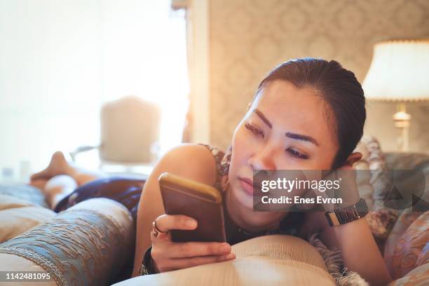 woman using mobile phone in bed - ghosted stock pictures, royalty-free photos & images