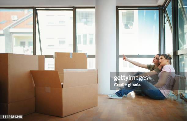 lesbian couple moving in together. - gay couple new house stock pictures, royalty-free photos & images