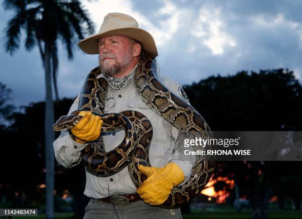 Tom Rahill, founder of Swamp Apes, handles a Burmese python as he speaks about the snake at Everglades Holiday Park in Fort Lauderdale, Florida on...