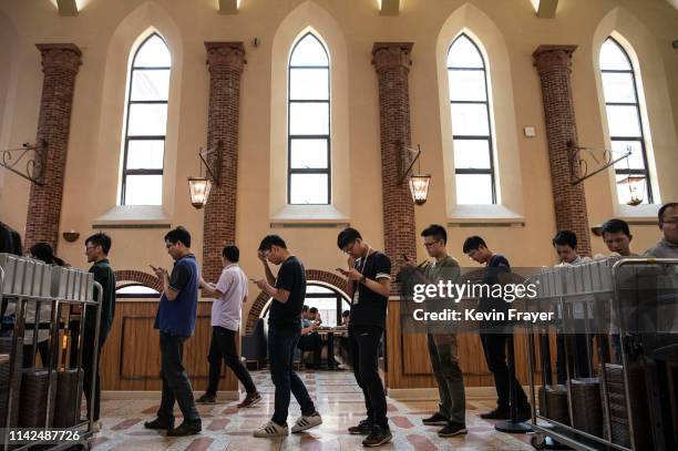 Huawei workers wait in line for lunch in a cafeteria designed in the style of a church at the sprawling 'Ox Horn' Research and Development campus on...