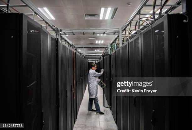 Huawei engineer opens the door a server unit to display during an organized tour at the Cyber Security Lab of the company's production campus on...