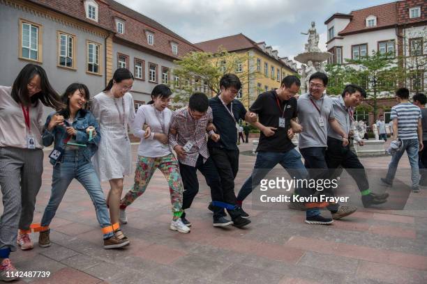 Huawei workers play a 'team building' game at the end of the lunch break at the new sprawling 'Ox Horn' Research and Development campus on April 24,...