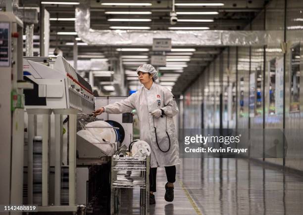 Worker packs up new smartphone devices at the end of the production line at Huawei's production campus on April 11, 2019 in Dongguan, near Shenzhen,...