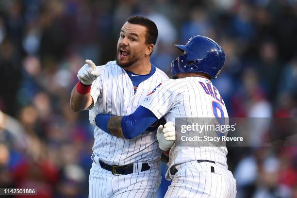 Kyle Schwarber of the Chicago Cubs is restrained by Javier Baez after being called out by the third base umpire during the ninth inning of a game...