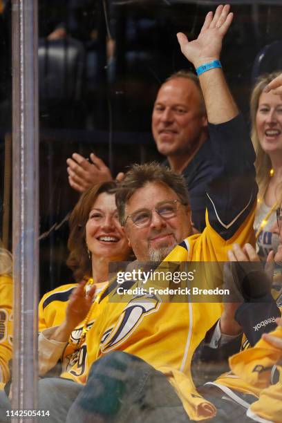 Country singer Vince Gill waves to fans after being wished a happy birthday on the jumbotron during the first period between the Nashville Predators...