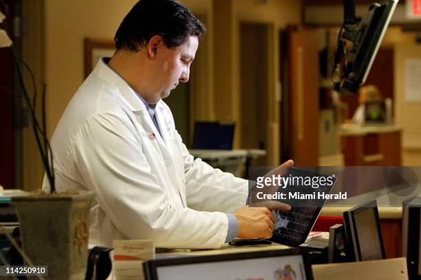 Cardiologist Dr. Jose Soler uses an app on an iPad to review medical tests of one of his patients at Northwest Medical Center in Margate, Florida, on...