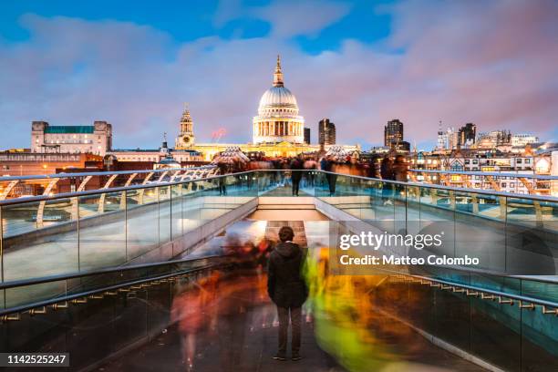 young man standing on millennium bridge at dusk, london - millennium bridge londra foto e immagini stock