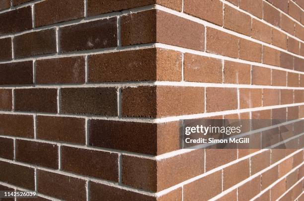 corner of a brown brick building exterior - brick wall building stock pictures, royalty-free photos & images