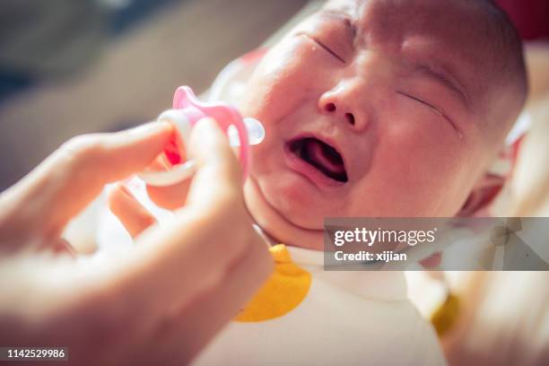 crying baby - pacifier stock pictures, royalty-free photos & images