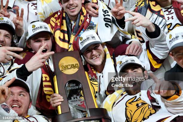 Hunter Shepard,Parker Mackay and the rest of the Minnesota-Duluth Bulldogs celebrate with the trophy after the 2019 NCAA Frozen Four the championship...