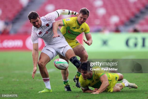 Harry Glover of England, Henry Hutchison and Simon Kennewell of Australia compete for the ball during the Cup quarter final between Australia and...