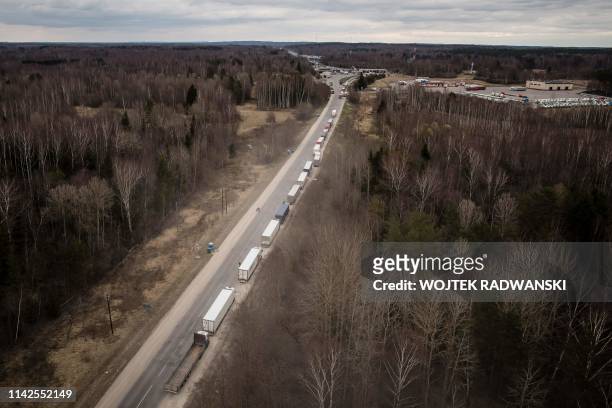 This aerial view shows trucks standing in lane before Terehova border pass between Russia and Latvia near Pasiene, eastern Latvia, on April 10, 2019....