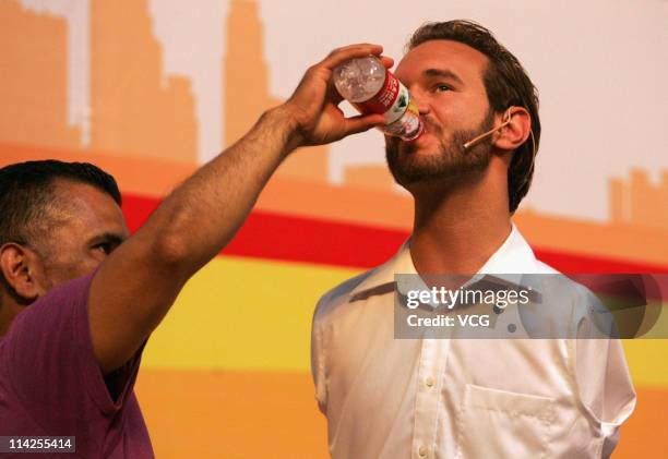 Australian preacher and motivational speaker Nick Vujicic drinks water with assistant's help during his public lecture at Northwestern Polytechnical...