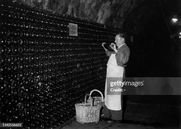 Wine maker prepares bottles in a wine cellar during grape harvest in Champagne in September 1945.