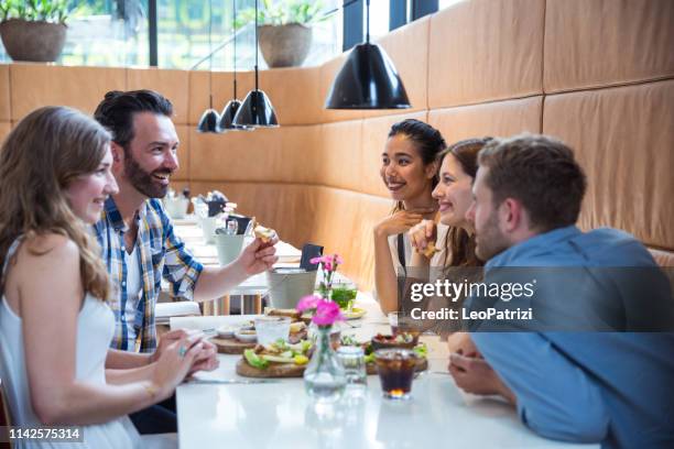 friends celebrating in a rooftop bar in amsterdam drinking fresh mojitos and cocktails - amsterdam cafe stock pictures, royalty-free photos & images