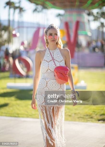 Leonie Hanne is seen wearing white sheer dress with fringes, red bag at the Revolve Festival during Coachella Festival on April 13, 2019 in La...