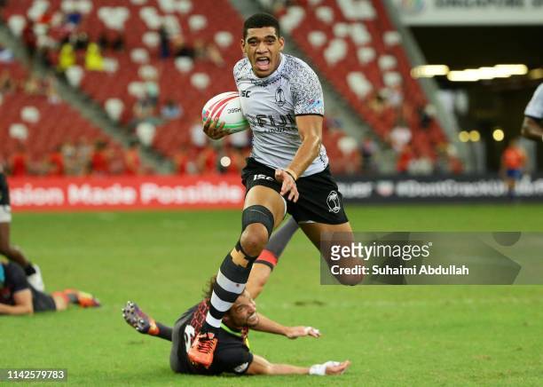 Meli Derenalagi of Fiji fends off the tackle by Tom Mitchell of England to score a try during the Cup semi final against Fuji and England on day two...