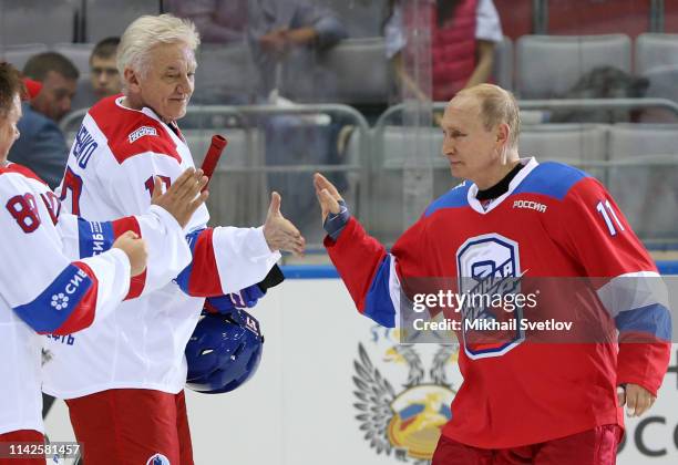 Russian President Vladimir Putin greets billionaire and businessman Gennady Timchenko during a group photo at the gala match of the Night Hockey...