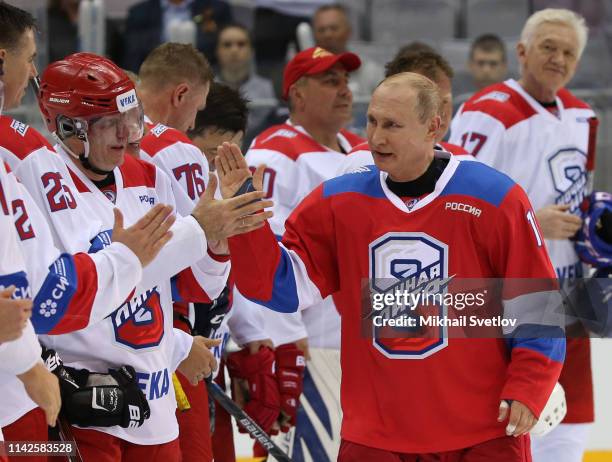 Russian President Vladimir Putin greets billionaire and businessman Vladimir Potanin as billionaire Gennady Timchenko looks on during a group photo...