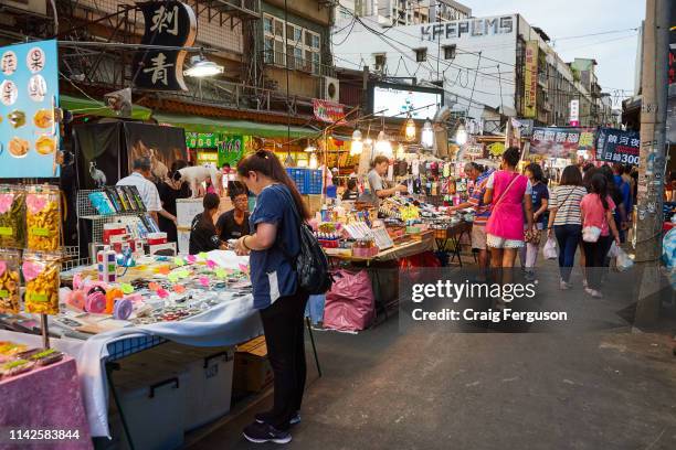 Tourists and locals walk around Raohe night market in the early evening. The market is one of the most popular in Taipei, with a wide variety of...