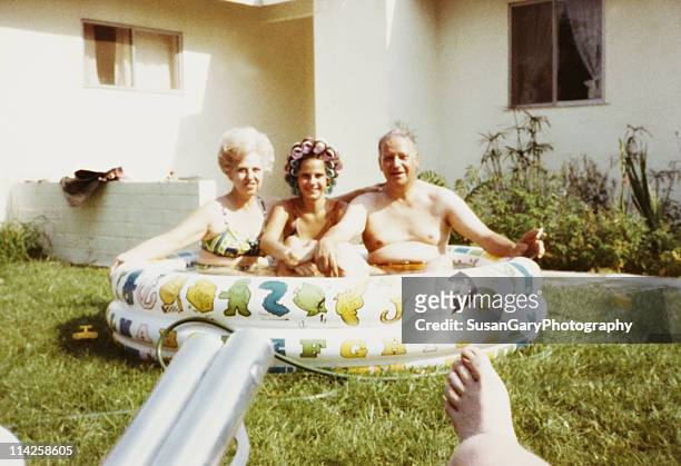 mother, daughter & father in kiddie pool 1971 - archival stock-fotos und bilder