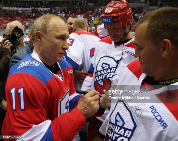 Russian President Vladimir Putin gives an autograph during the gala match of the Night Hockey League at Bolshoi Ice Dome on May 10, 2019 in Sochi,...