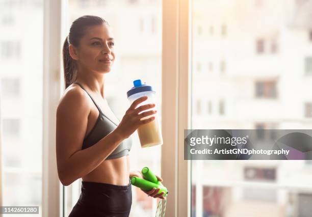 bodybuilder girl relax after exhausting training, young athlete drinking sports drink after workout, beautiful woman resting after exercising training. - protein stock pictures, royalty-free photos & images