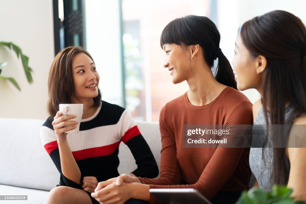 Chinese females talk together with digital tablet