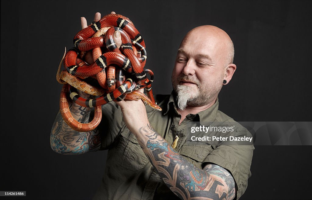 Snake handler holding corn and Pueblan milk snakes