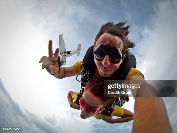 skydive tandem selfie couple - face wind photos et images de collection