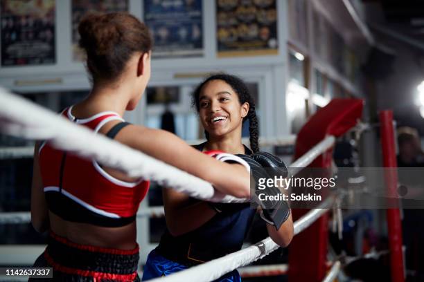 two laughing teenage girls together in boxing ring - boxning sport photos et images de collection