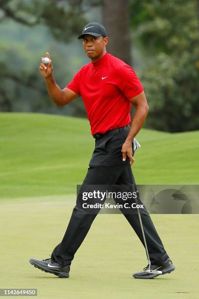 Tiger Woods of the United States waves after making a birdie on the eighth hole during the final round of the Masters at Augusta National Golf Club...