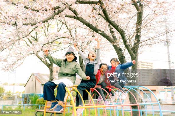 日本の女の子は公園で遊んでいる - 日本　手にもつ　外　仲間 ストックフォトと画像