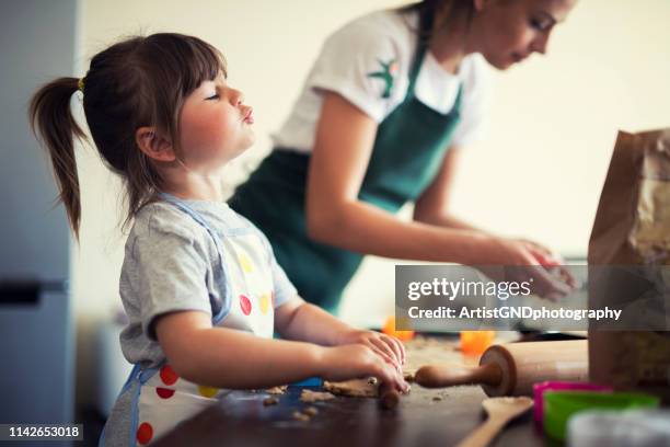 niedliches kleines mädchen, das zu hause mit mama backt - kids baking stock-fotos und bilder