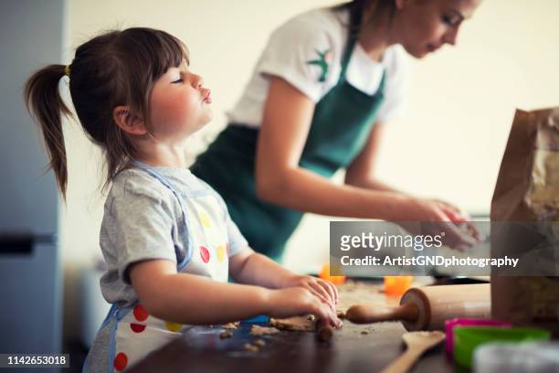 söt liten flicka baka hemma med mamma - bakery apron bildbanksfoton och bilder