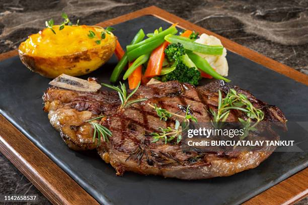 grilled steak with prepared potato and steamed vegetables - rib eye steak stockfoto's en -beelden