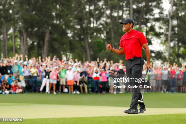Tiger Woods of the United States celebrates after sinking his putt to win on the 18th green during the final round of the Masters at Augusta National...