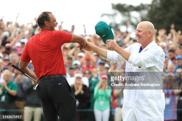 Tiger Woods of the United States celebrates with caddie Joe LaCava on the 18th green after winning during the final round of the Masters at Augusta...