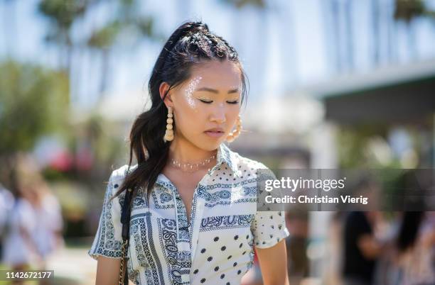 Jaime Xie is seen with festival make up and earrings at the Revolve Festival during Coachella Festival on April 13, 2019 in La Quinta, California.