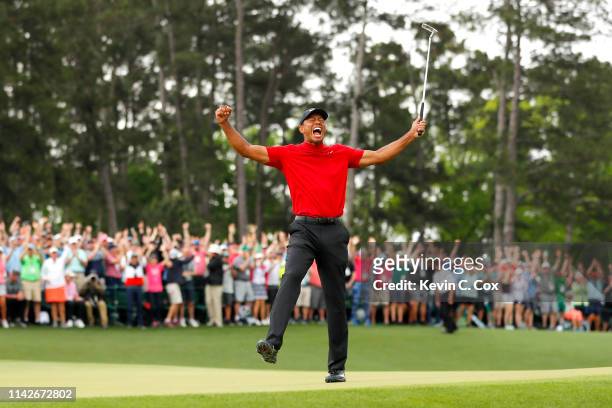 Tiger Woods of the United States celebrates after sinking his putt on the 18th green to win during the final round of the Masters at Augusta National...