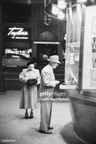 Man buys a ticket to a film at the Egyptian Theatre on Hollywood Boulevard, Los Angeles, 1951. Original Publication : Picture Post - 5298 - Two Men...