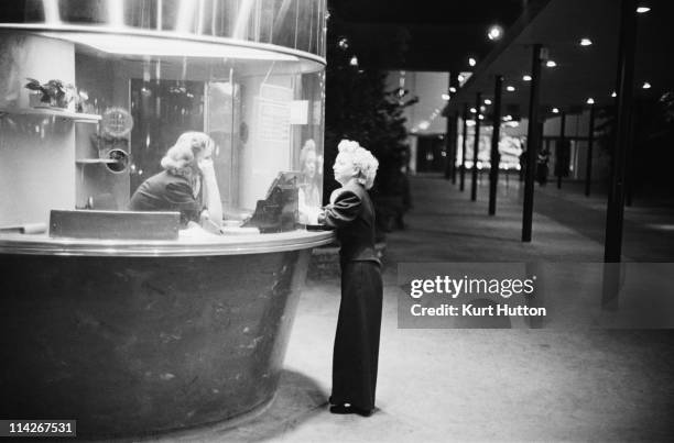 Woman buys a ticket to a film at the Egyptian Theatre on Hollywood Boulevard, Los Angeles, 1951. Original Publication : Picture Post - 5298 - Two Men...